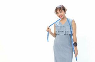 portrait a young confident asian female standing,there are a tape measure around her neck,a pin pillow on her wrist,isolated on white background with copy space,concept of business,design,tailoring photo