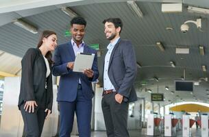 business inspectors using tablet and talking about business together in front of skytrain fare gates photo