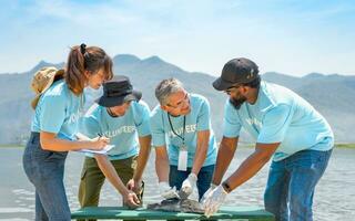 volunteers led by a biologist  injecting microchips to reproduce fish by the river for conservation of rare fish species photo