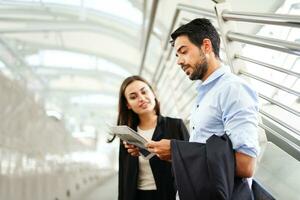 businessman reading newspaper and chatting with secretary outside building,selective focus with businessman photo