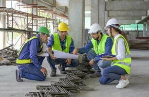 engineer project manager inspecting the structural standards of new building construction,engineers team in safety uniform working outside office in the building under construction site photo