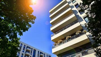 Modern apartment building and green trees. Ecological housing architecture. photo