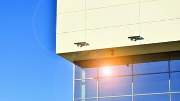 Minimalist photo of an exterior of a modern tin building with big glass showcases.