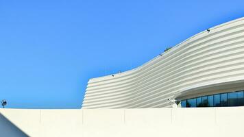 Minimalist photo of an exterior of a modern tin building with big glass showcases.