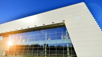 Minimalist photo of an exterior of a modern tin building with big glass showcases.