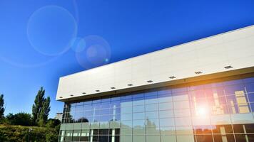 Minimalist photo of an exterior of a modern tin building with big glass showcases.