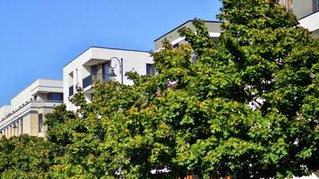 Green community. Eco apartment building saving energy and fresh air concept. Block of flats in beautiful green public photo