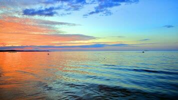 un verano puesta de sol paisaje en el horizonte. mar en dorado colores y increíble nubes en cielo. foto