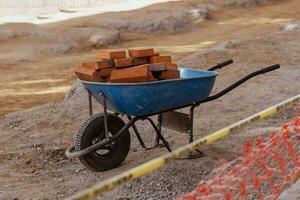 wheelbarrow full of red bricks in repair work photo