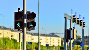 Pedestrian and bicycle traffic light with bicycle icon and active green resolving light on the background of summer city photo