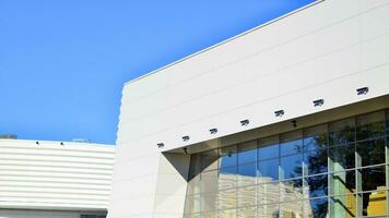 Minimalist photo of an exterior of a modern tin building with big glass showcases.