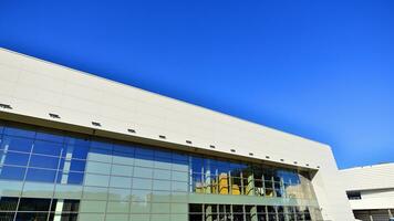 Minimalist photo of an exterior of a modern tin building with big glass showcases.