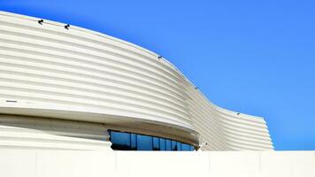 Minimalist photo of an exterior of a modern tin building with big glass showcases.