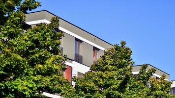 Green community. Eco apartment building saving energy and fresh air concept. Block of flats in beautiful green public photo