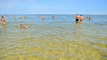 Swinoujscie, Poland. 15 August 2023. People in the water on the beach during holiday season in over Baltic Sea. photo