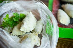 Raw green dough dumplings with parsley, dill. photo