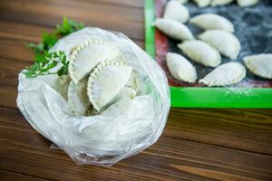 Raw green dough dumplings with parsley, dill. photo