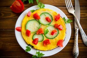 frito tortilla con calabacín, Tomates, hierbas en un plato foto