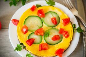 frito tortilla con calabacín, Tomates, hierbas en un plato foto