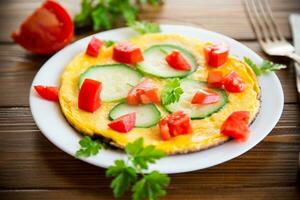 frito tortilla con calabacín, Tomates, hierbas en un plato foto