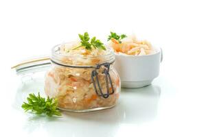Sauerkraut with carrots and spices in a glass jar photo