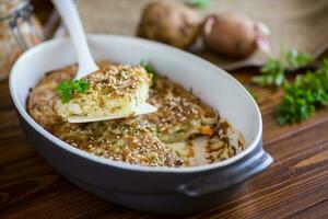 potato casserole with cabbage and spices in a ceramic form photo