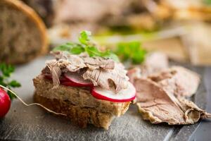 sandwich with baked meat, radish and herbs photo