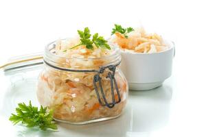 Sauerkraut with carrots and spices in a glass jar photo