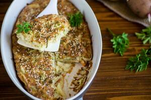 potato casserole with cabbage and spices in a ceramic form photo