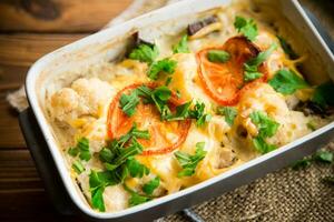 cauliflower baked with chicken fillet and mushrooms under cheese in a ceramic form photo