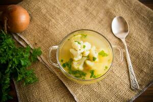 cooked chicken soup with cauliflower and vegetables in a bowl photo