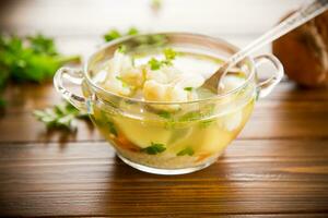 cooked chicken soup with cauliflower and vegetables in a bowl photo