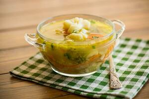 cocido pollo sopa con coliflor y vegetales en un cuenco foto