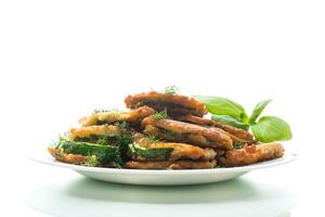 zucchini fried in circles in batter with herbs, in a plate. photo