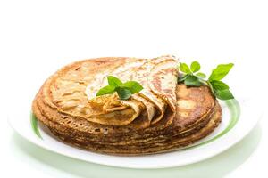 lot of pancakes thin pancakes in a plate, on white background. photo