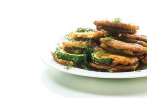 zucchini fried in circles in batter with herbs, in a plate. photo