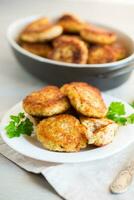 Cooked fried fish cutlets in a plate with herbs. photo