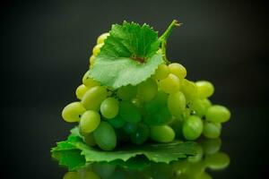 A bunch of ripe green grapes with leaves. photo