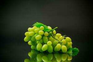 A bunch of ripe green grapes with leaves. photo