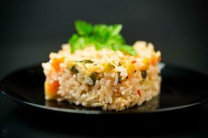 Cooked boiled rice with zucchini, carrots and vegetables in a plate photo