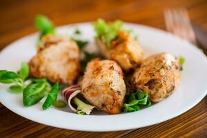 Fried pieces of chicken fillet breaded with spices and herbs in a plate . photo