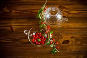 Branch with ripe red goji berry on wooden table photo