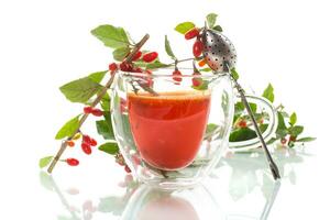 Prepared hot drink from ripe goji berries in a glass cup photo