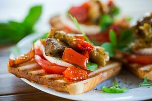 Prepared sandwich with tomatoes, mozzarella and fried eggplant with mushrooms. photo