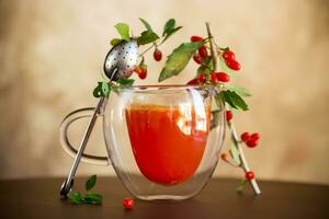 Prepared hot drink from ripe goji berries in a glass cup photo