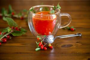 Prepared hot drink from ripe goji berries in a glass cup photo