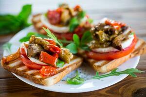 Prepared sandwich with tomatoes, mozzarella and fried eggplant with mushrooms. photo