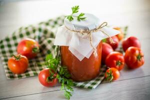 cocido hecho en casa tomate jugo Enlatado en un tarro de natural Tomates. foto