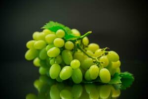 A bunch of ripe green grapes with leaves. photo