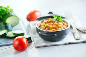 Cooked white beans with zucchini and other vegetables. photo